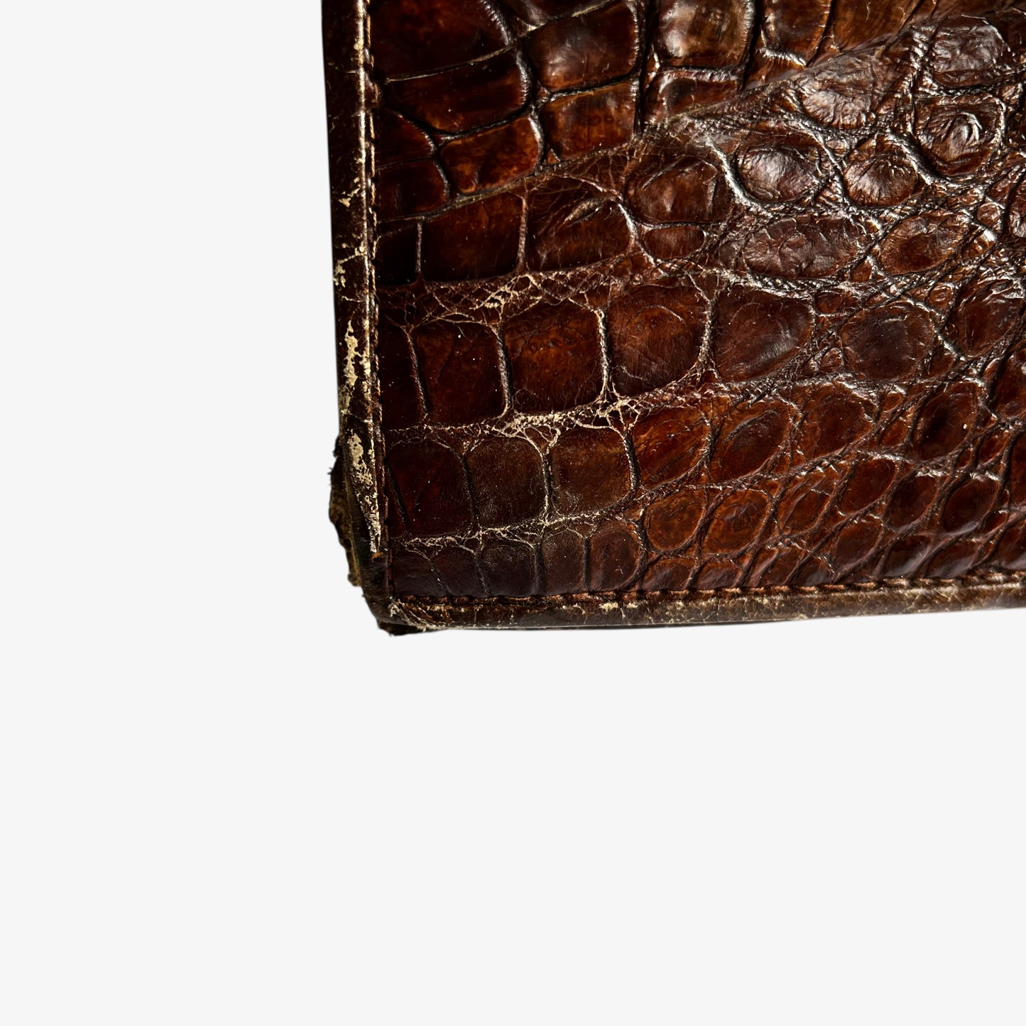 Patina on the bottom of a vintage 1950s brown crocodile leather shoulder bag.