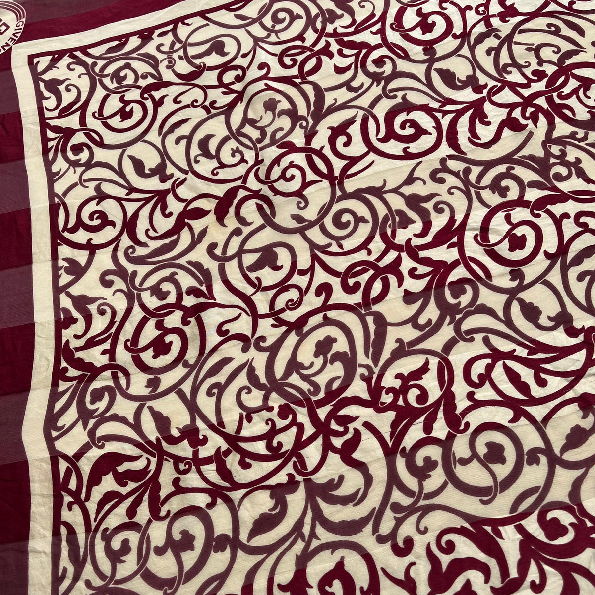 Close up of abstract floral design on a women's vintage 80s Givenchy red silk scarf.