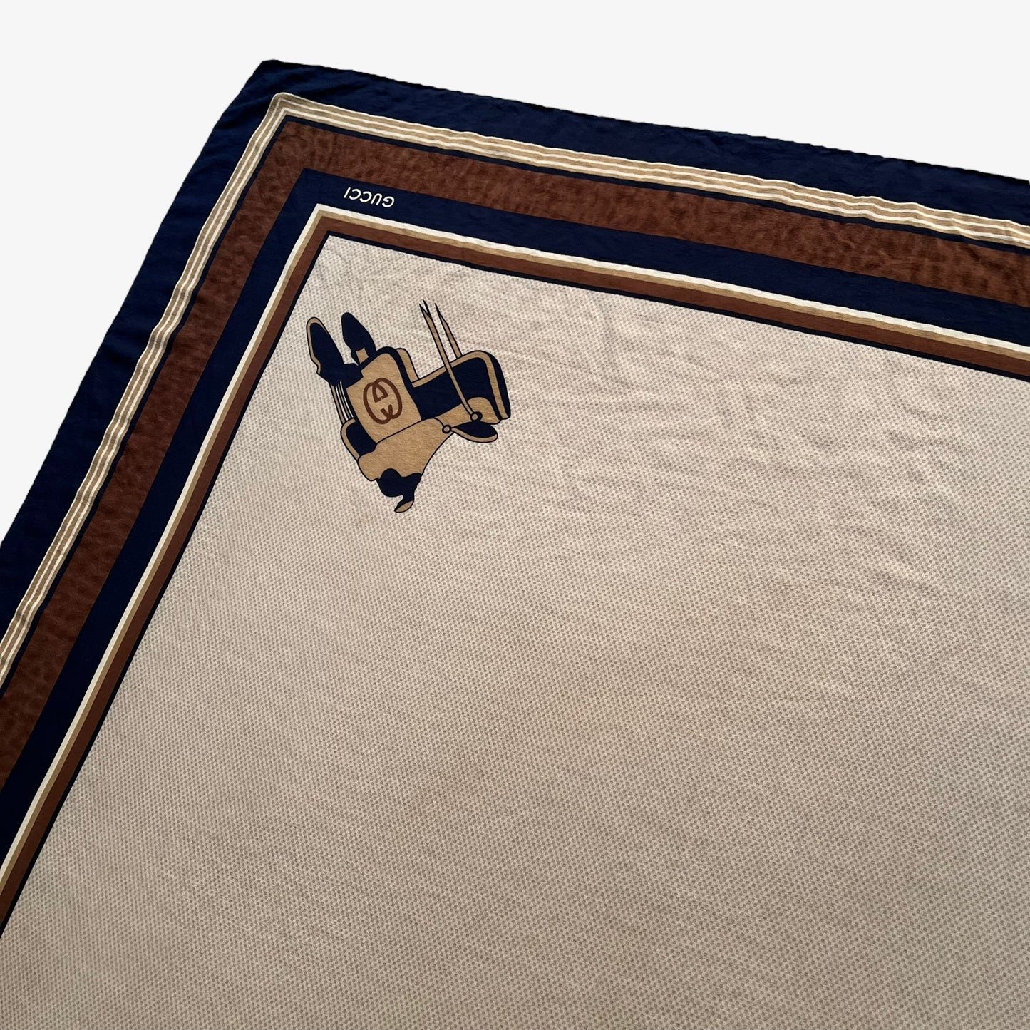 Equestrian saddle pattern of women's vintage 80s Gucci brown silk scarf with a GG interlocking pattern.