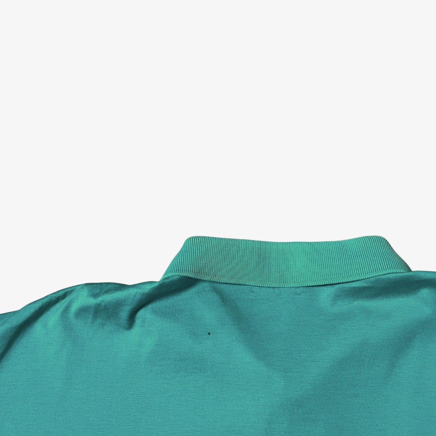 Patina on the back of a vintage 80s men's Fila green polo shirt.