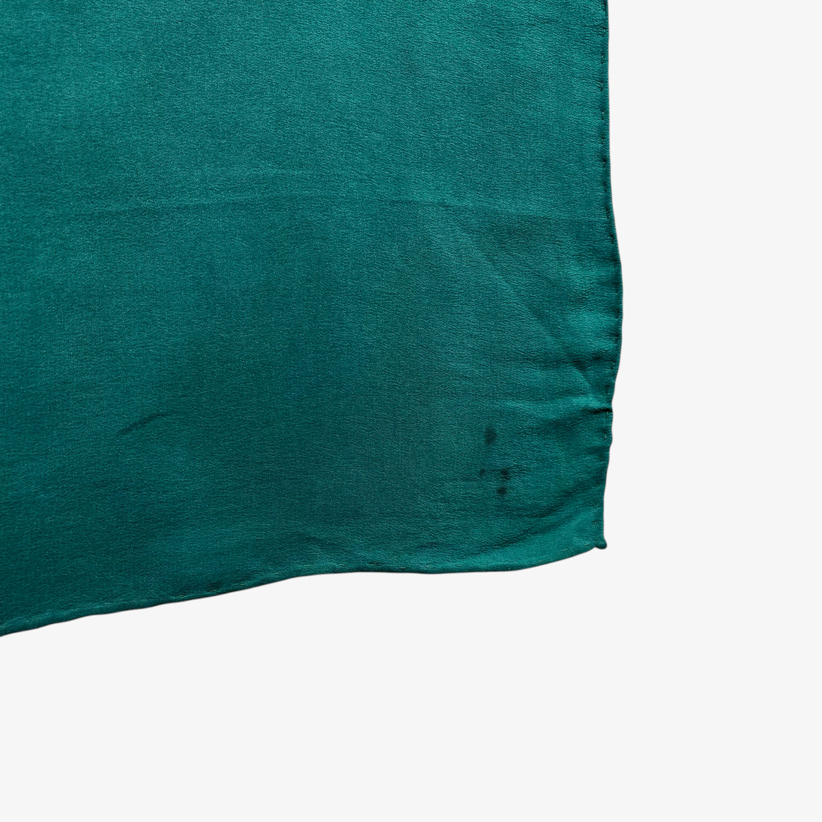 Faded corner of women's vintage 80s Yves Saint Laurent colourful abstract print green silk scarf.