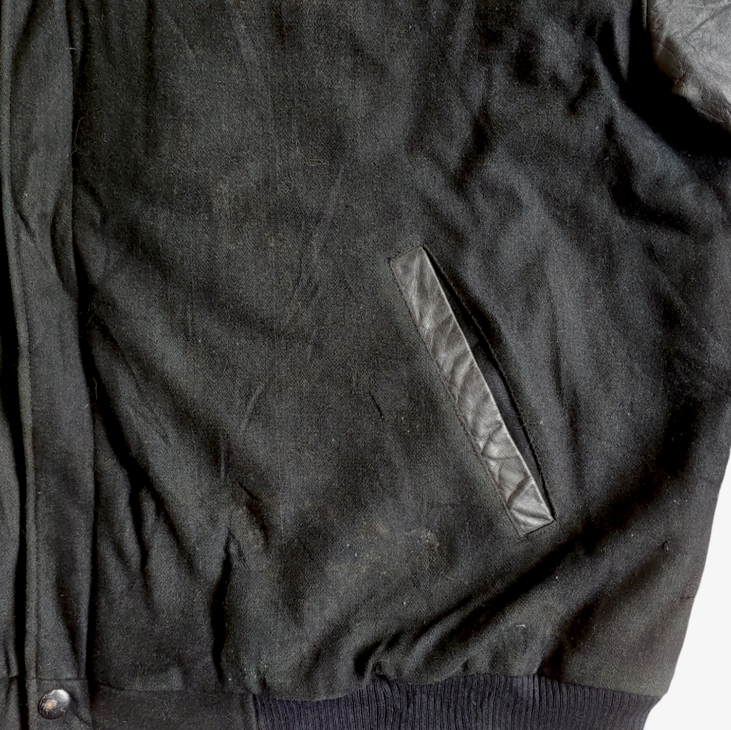Wear on a black vintage leather varsity jacket.