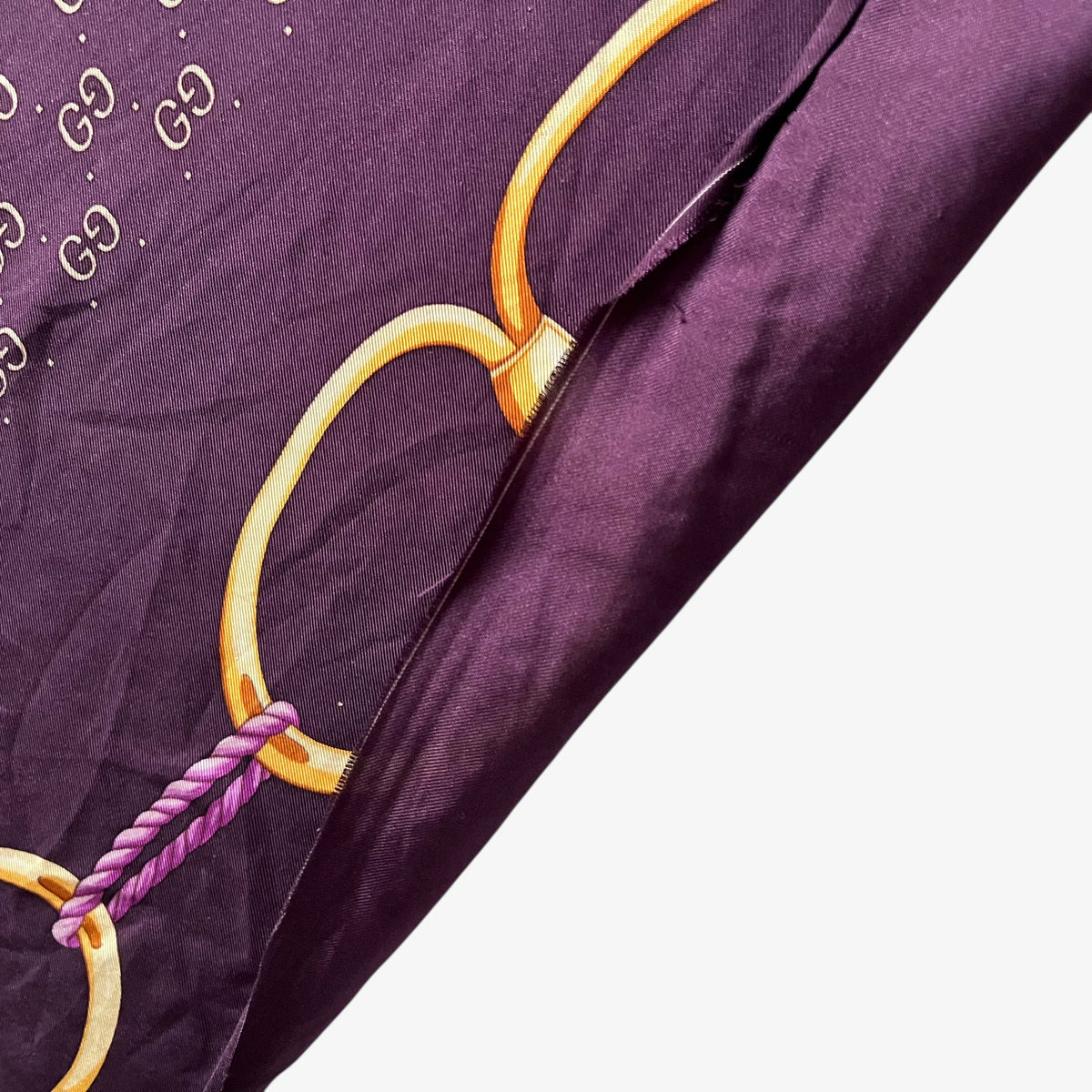Frayed edges on women's vintage 90s Gucci gold tassel chain print purple silk scarf with a geometric interlocking GG pattern.