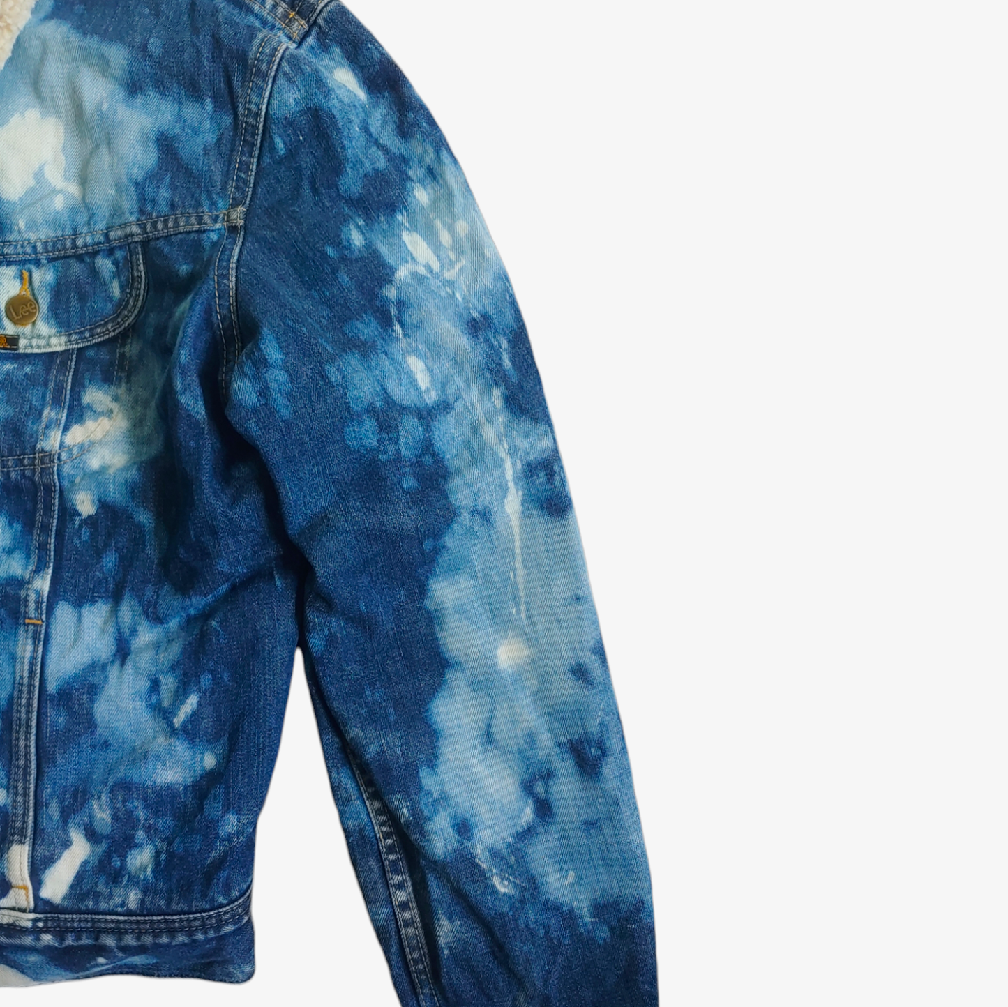 Sleeve of vintage Lee blue tie-dye denim trucker jacket with faux fur sherpa lining.