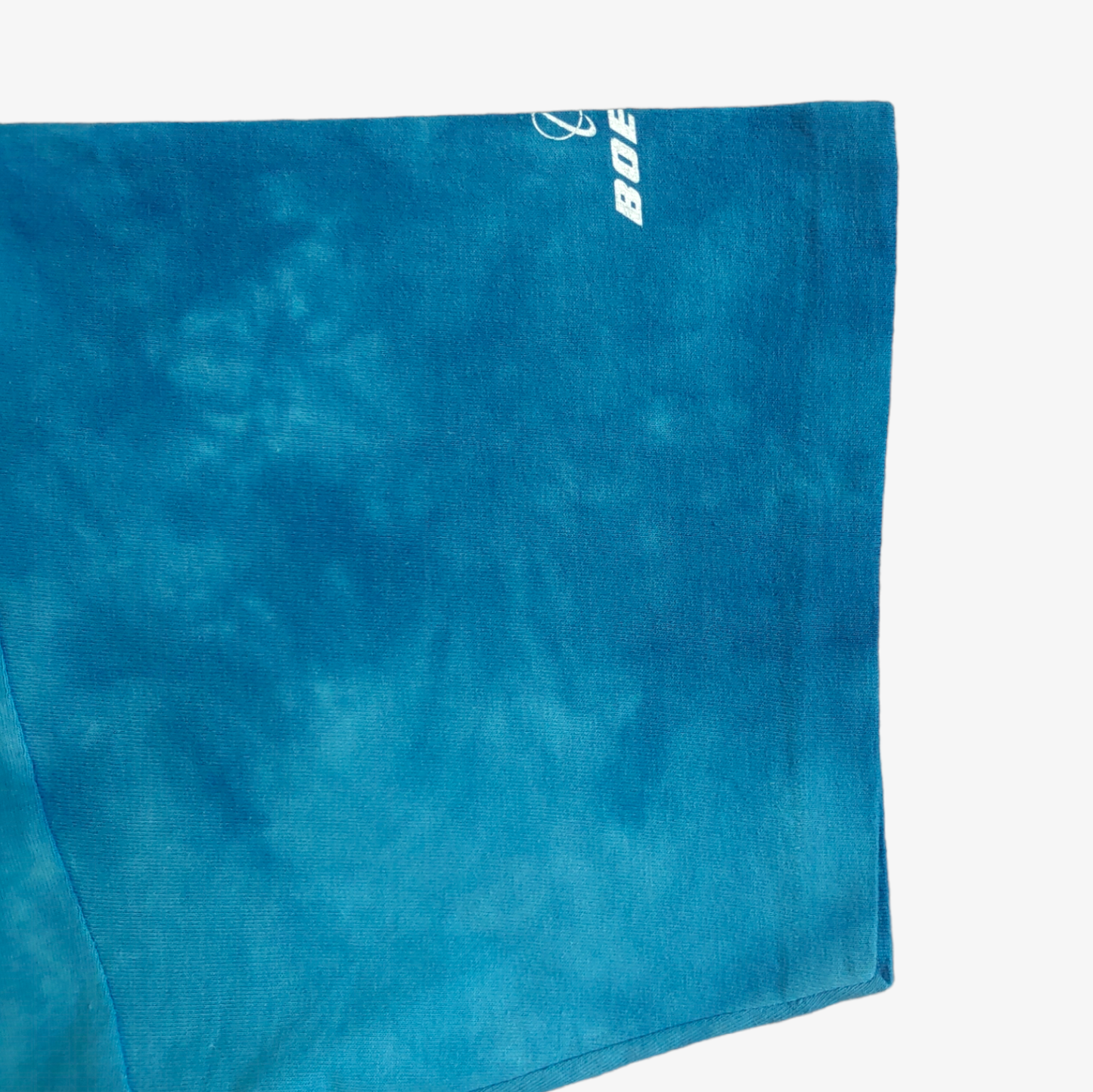 Single stitch cuff of a tie-dye print Liquid Blue Apache vintage 90s t-shirt featuring a helicopter graphic in blue and green shades.