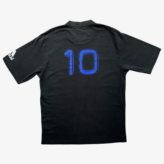 Vintage Adidas black short-sleeve t-shirt shown from the back, featuring the number 10 in blue on the back and a white Adidas logo on the sleeve, set against a light grey background.