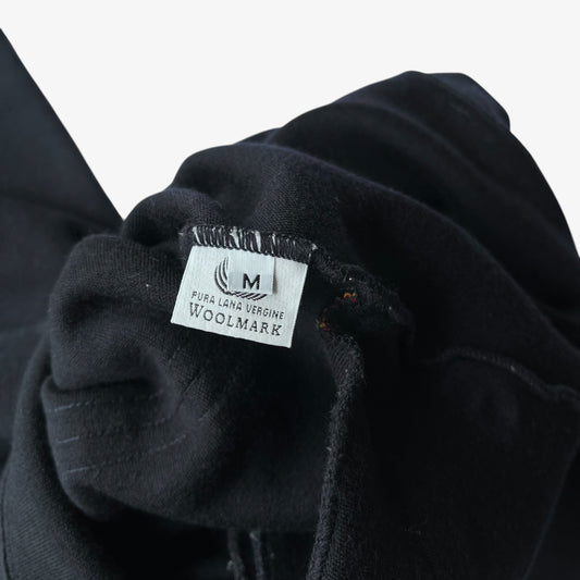 Close-up of a navy wool quarter zip fleece showing the inner pure new wool label.