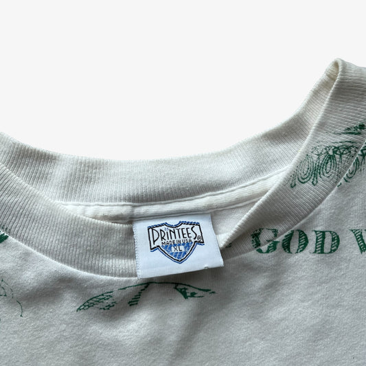 Close-up of a vintage white crewneck t-shirt with green graphic text and a white brand label reading Printees at the collar.