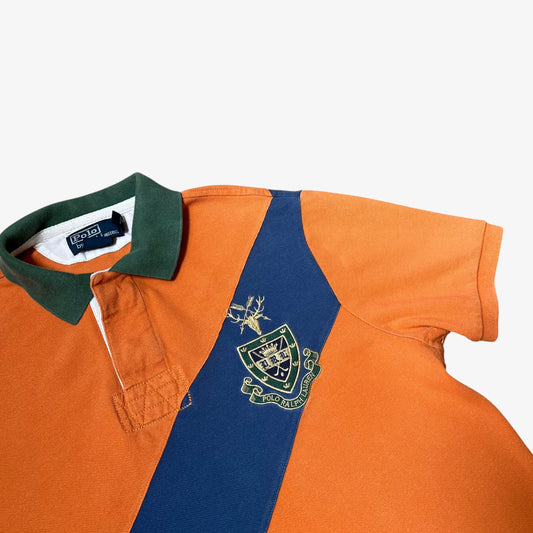 Close up of embroidered crest on vintage Ralph Lauren orange rugby shirt.