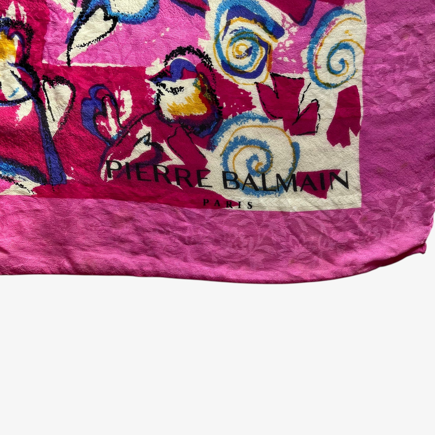 Pierre Balmain Paris spell out logo on women's vintage 90s Pierre Balmain Paris pink silk scarf features a colourful abstract floral print.