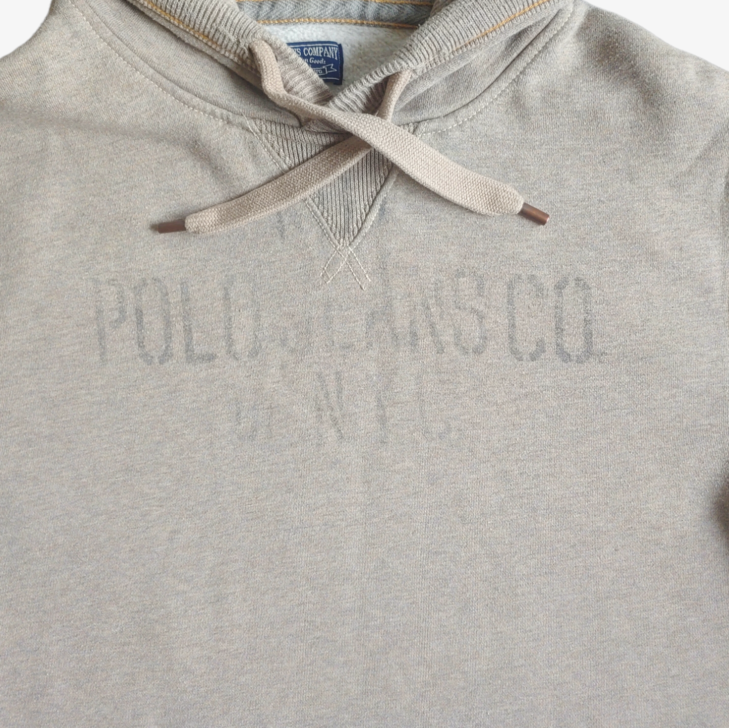 Close up of printed spell out on a vintage 90s Ralph Lauren Polo Jeans Company grey hoodie.