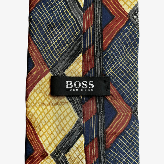 Label on vintage Y2K Hugo Boss contrasting colourful striped and checkered print silk tie.