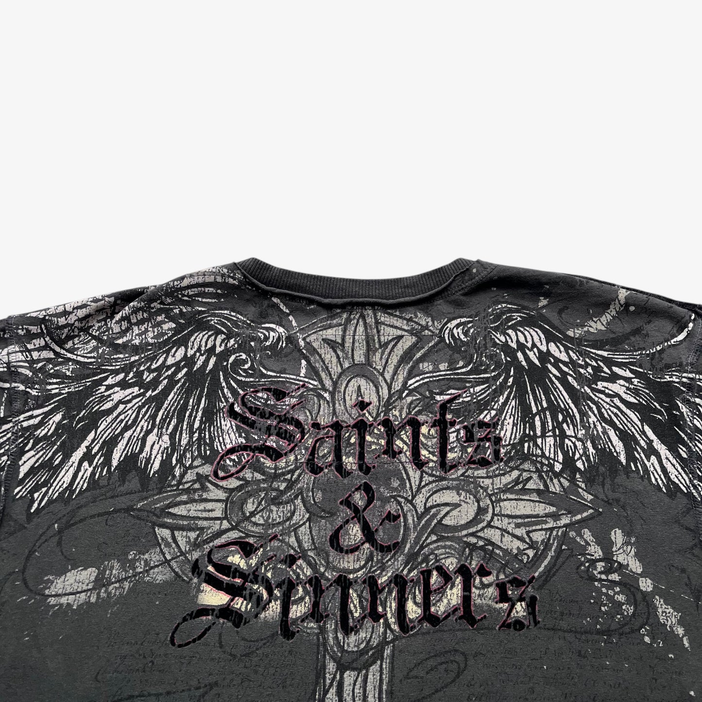 Close up of a saints and sinners spell out on the back of a men's vintage grey t-shirt.