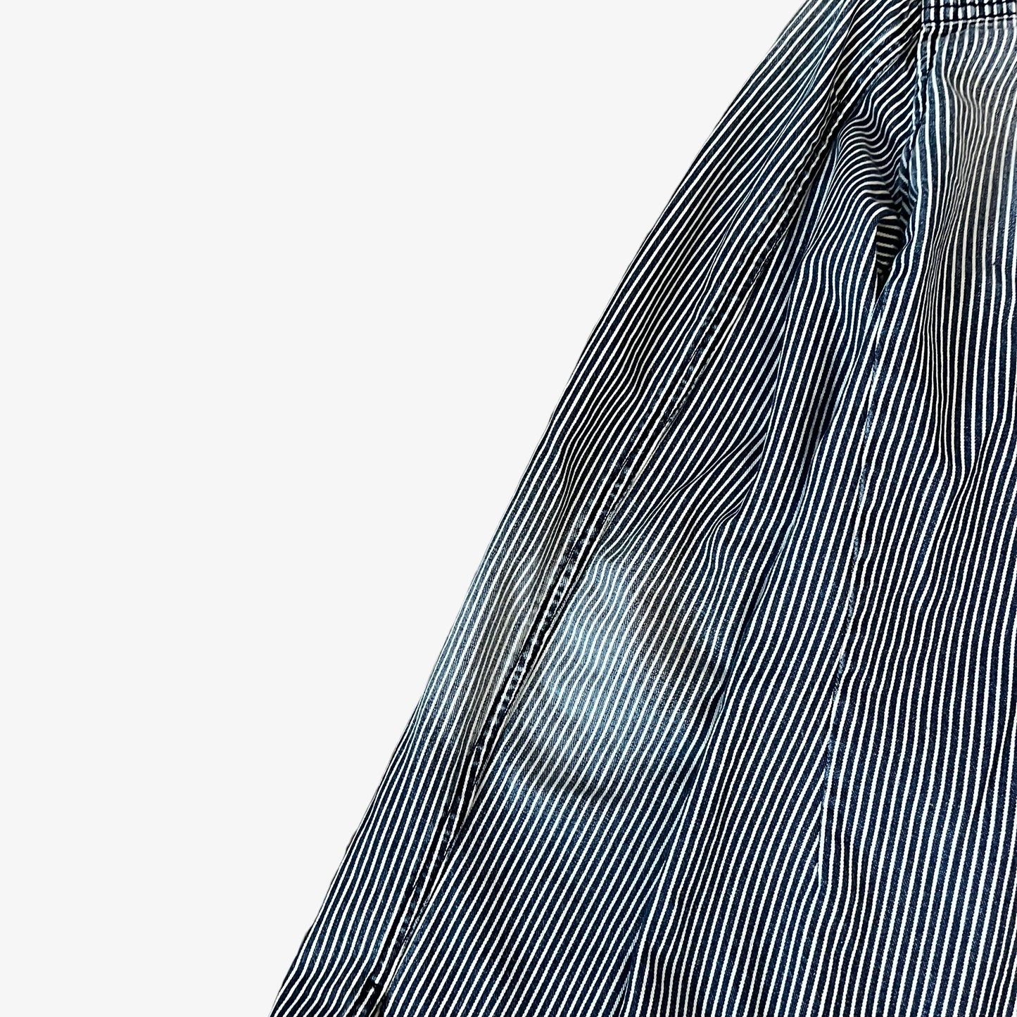 Sleeve of vintage Y2K men's Emporio Armani faded blue and white striped workwear jacket.