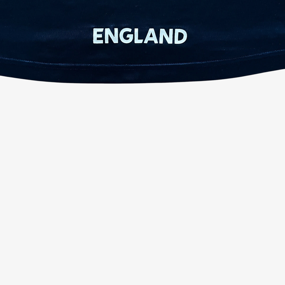 Close-up of a dark navy blue fabric with the word 'ENGLAND' printed in white across the top edge, set against a plain white background.