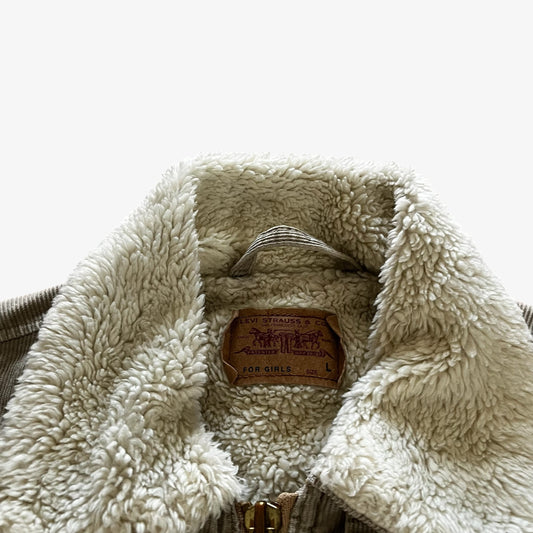 Close-up of a sherpa fleece-lined jacket collar with a visible brown leather patch.