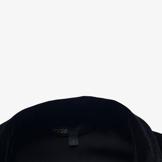 Maje label inside of a women's black velour shirt on a white background.