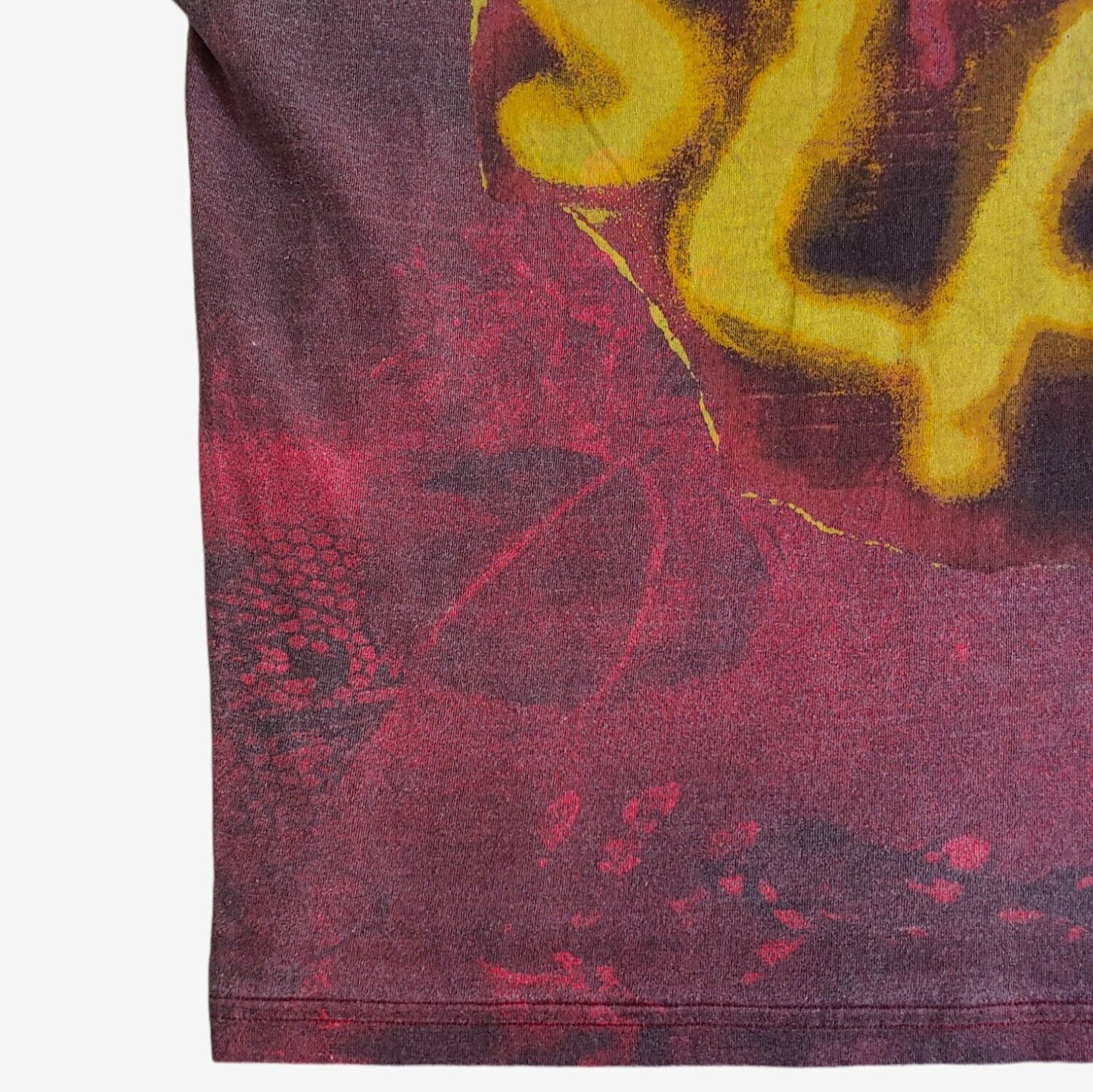 Hem of vintage 90s men's Reebok tie-dye t-shirt with 'SLAM' printed in yellow bold letters on the front.