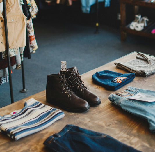 Wooden table with a collection of vintage clothing and accessories on it.