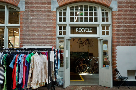 Photo of an entrance to a recycling shop which is filled with second hand clothing.