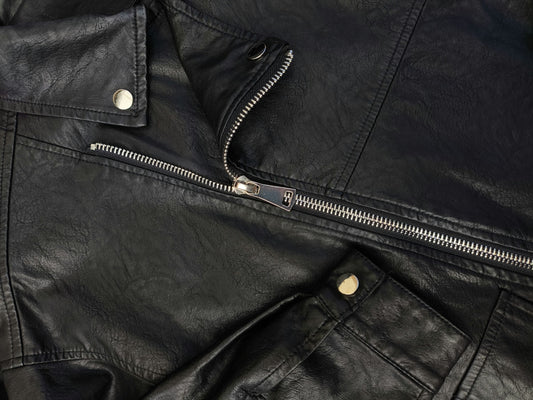 Close up of the patina on a vintage 90s black leather biker jacket.