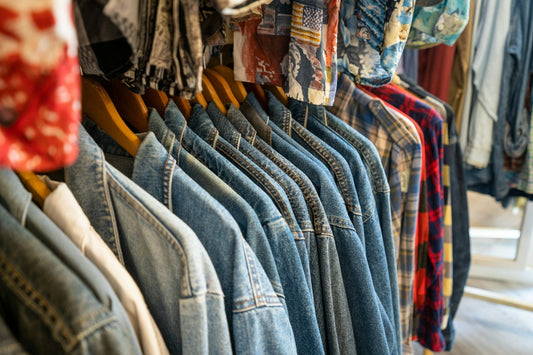 Row of vintage denim jackets hanging up on a rail.