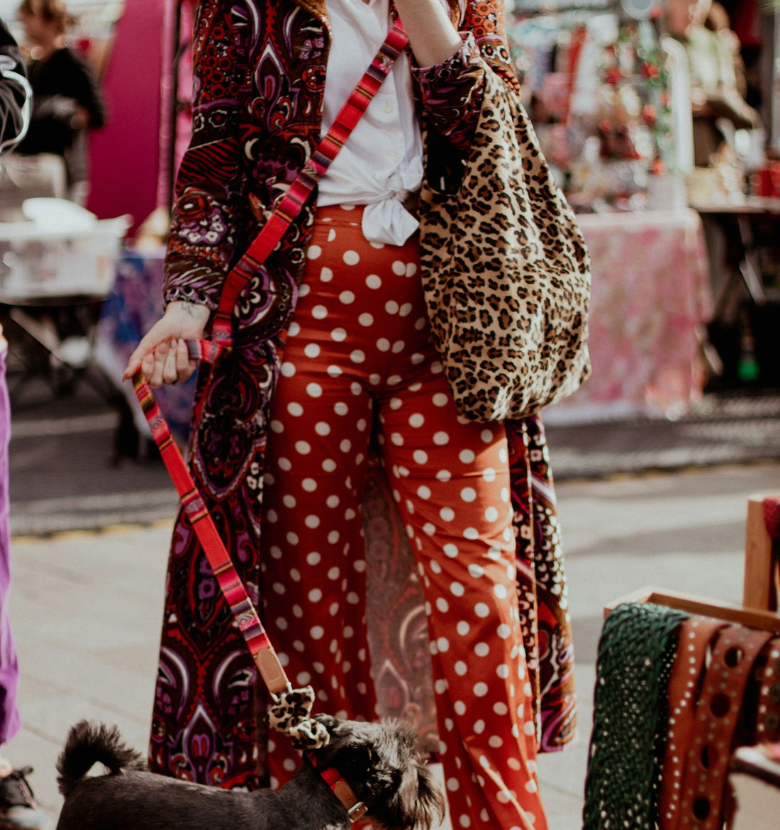 A female model wearing a vintage 60s leopard print coat with a pair of retro red and white polka dot jeans.