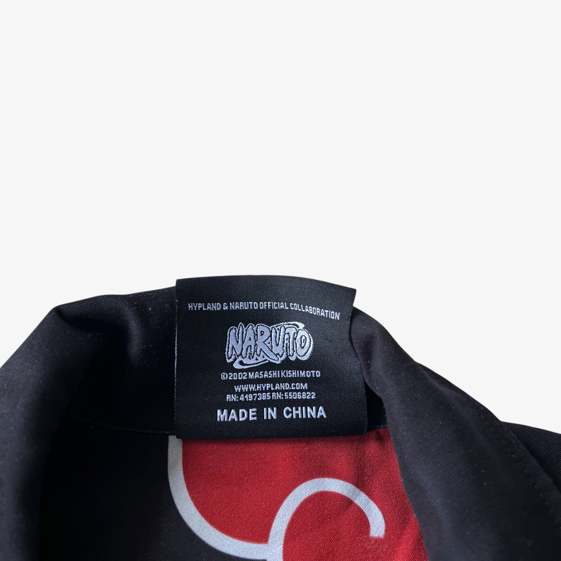 Close up of a label with Naruto Masaski Kishimoto 2002 branding on a black Hypland shirt.