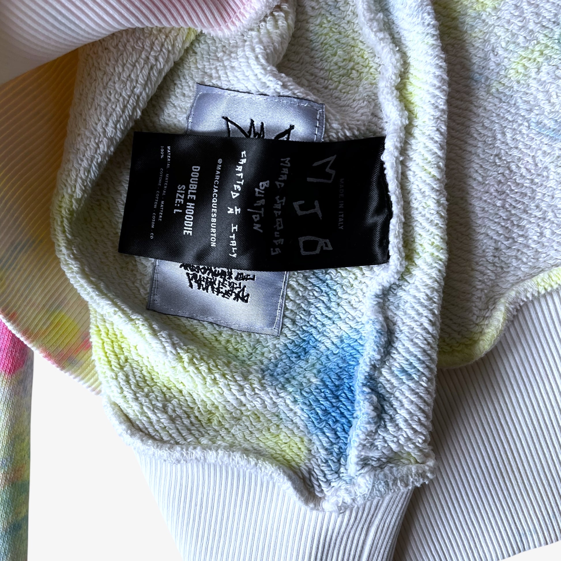 Close up of a textured fabric with a brand label on a multicoloured background.