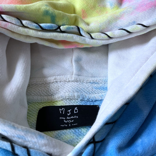 Close up of a colourful fabric with a label inside, featuring the text 'MJB'.