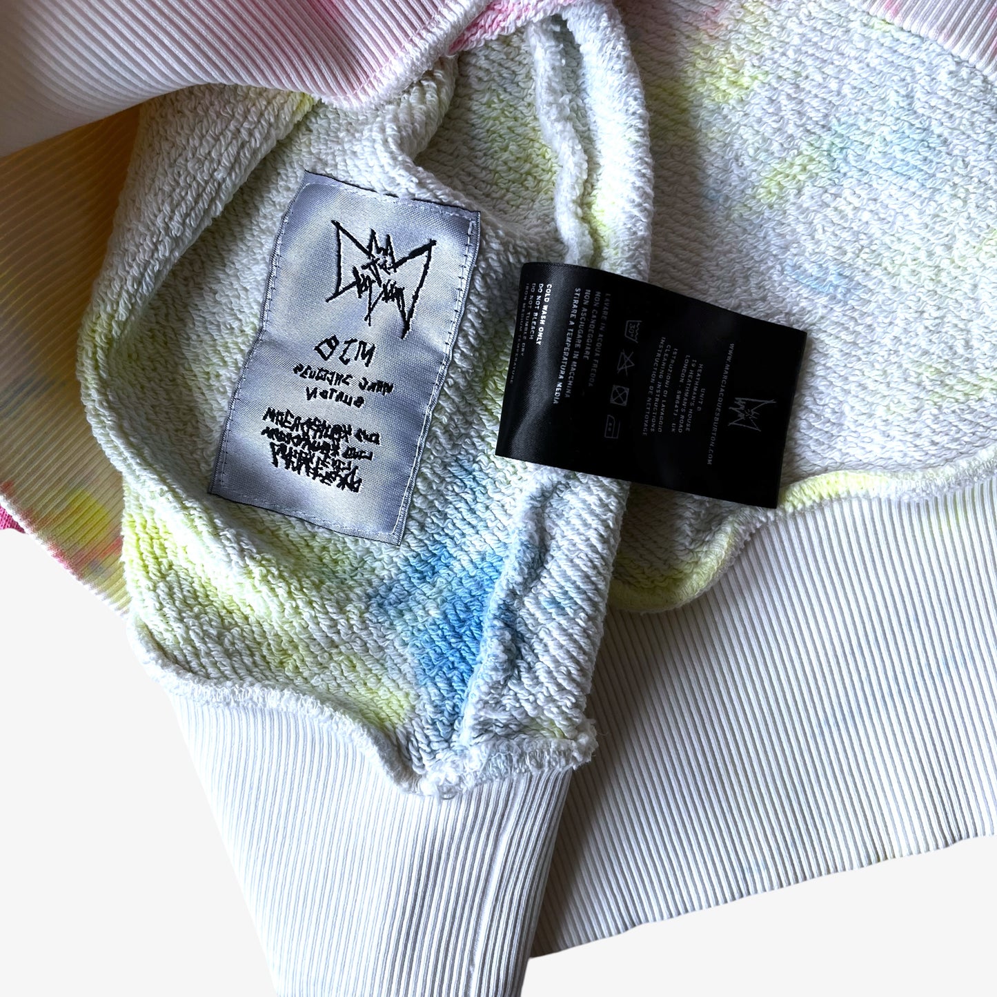 Close up of a multicoloured fabric with brand labels on a white background.