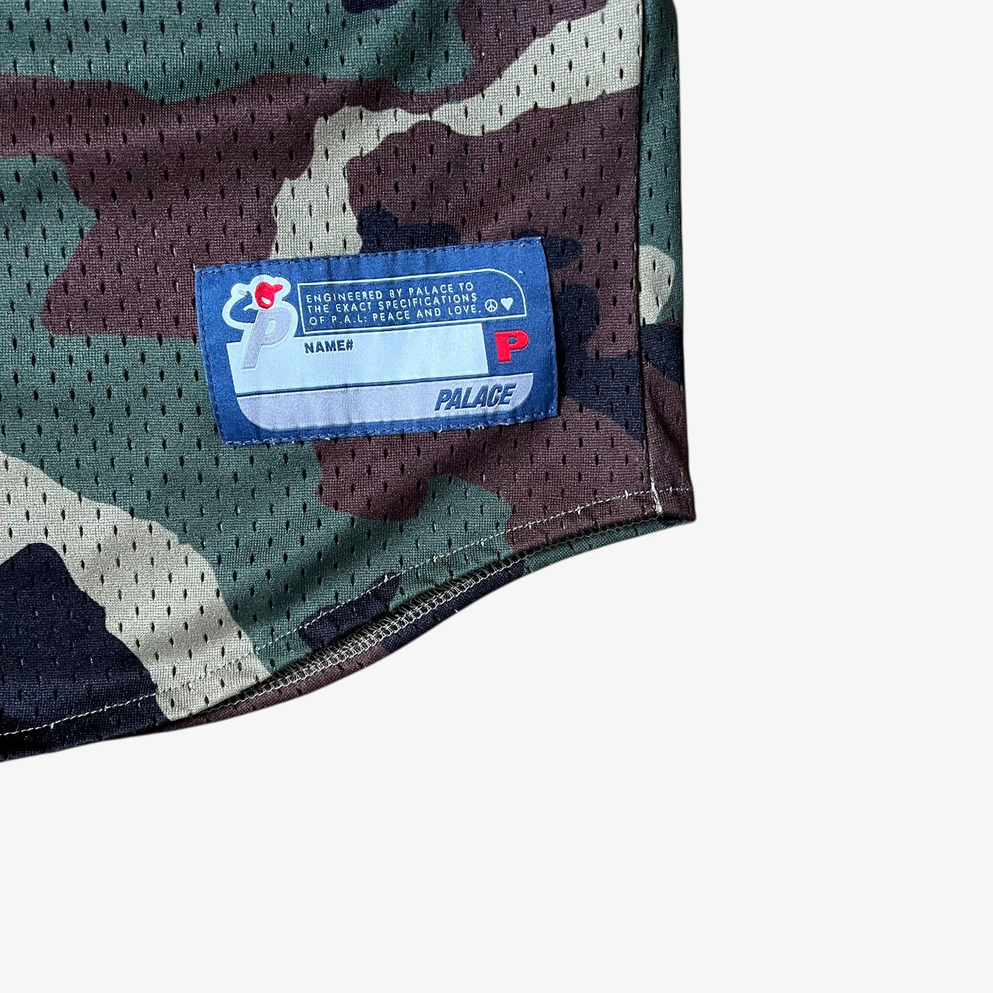 Stitched brand tag on men's Palace kawaii green camouflage baseball jersey.