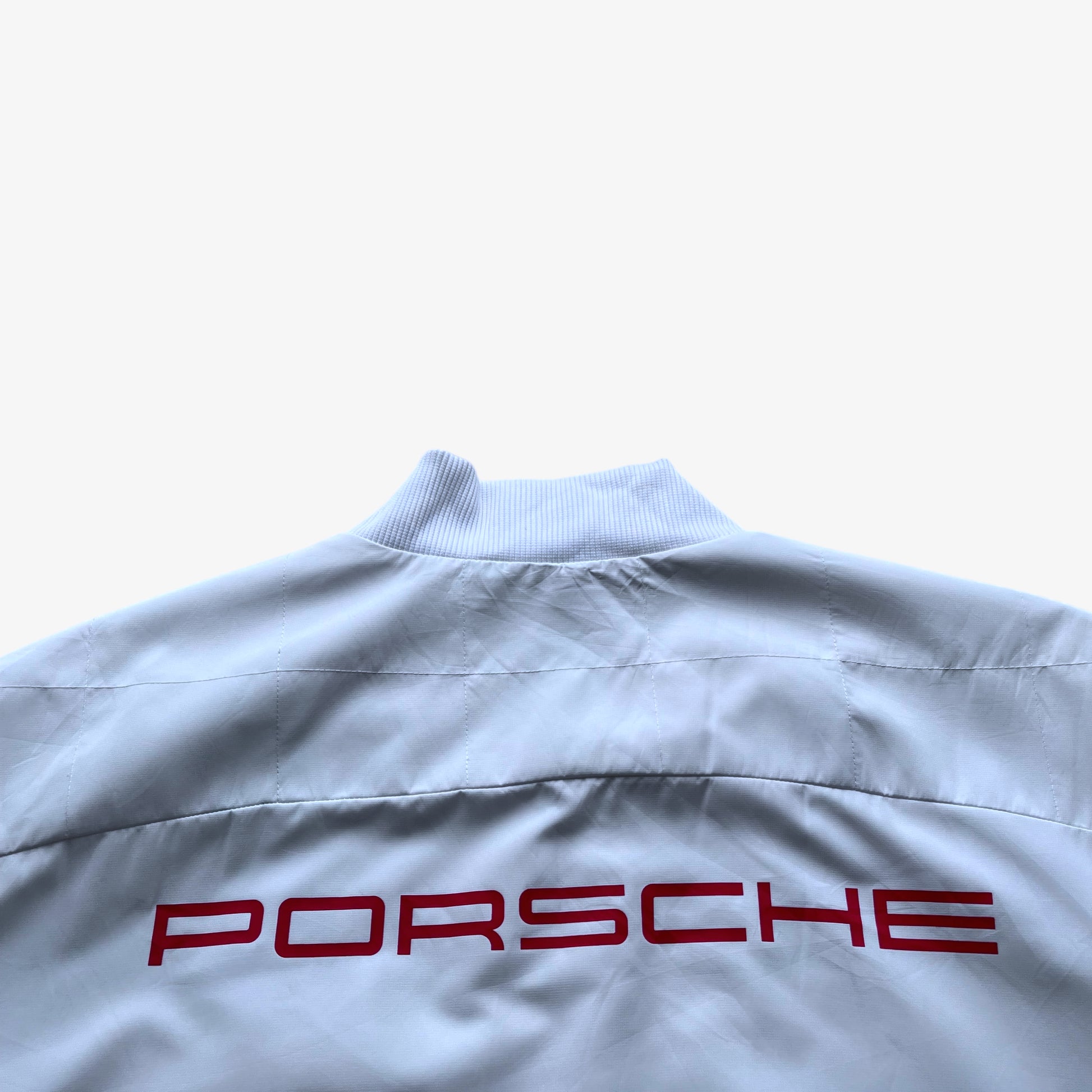 Porsche printed spell out on the back of men's Puma 911 GT3R white driving jacket.