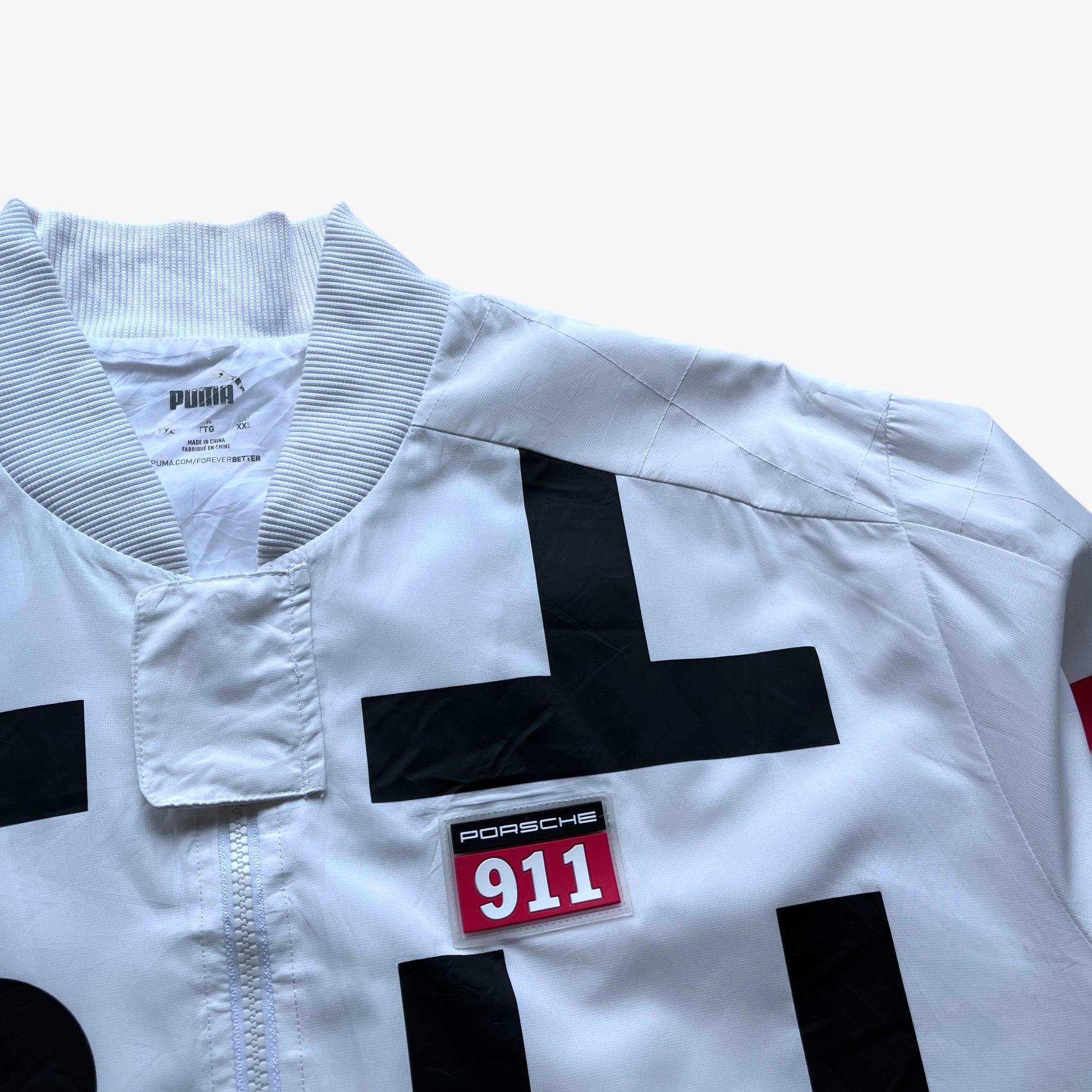 Porsche 911 embroidered logo on men's Puma GT3R spell out print white driving jacket.