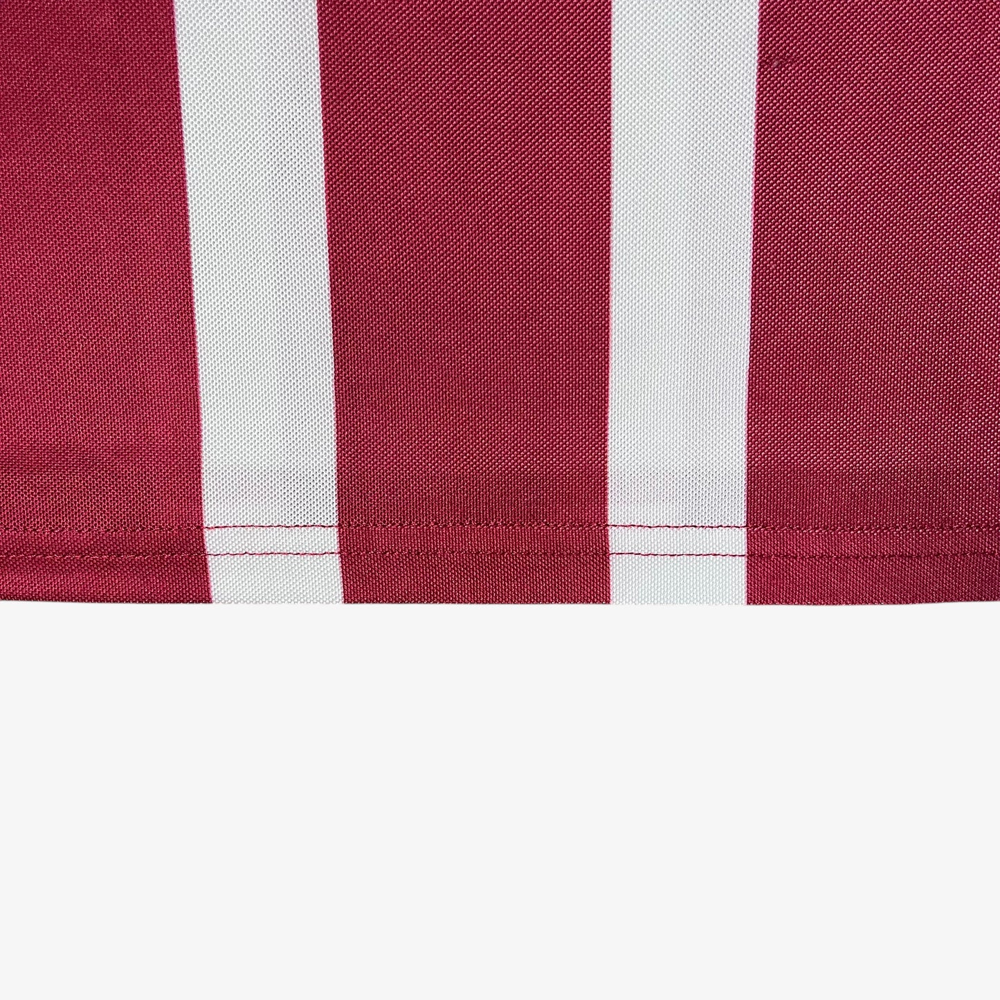 Cropped hem of men's Scuffers red and white striped football jersey.