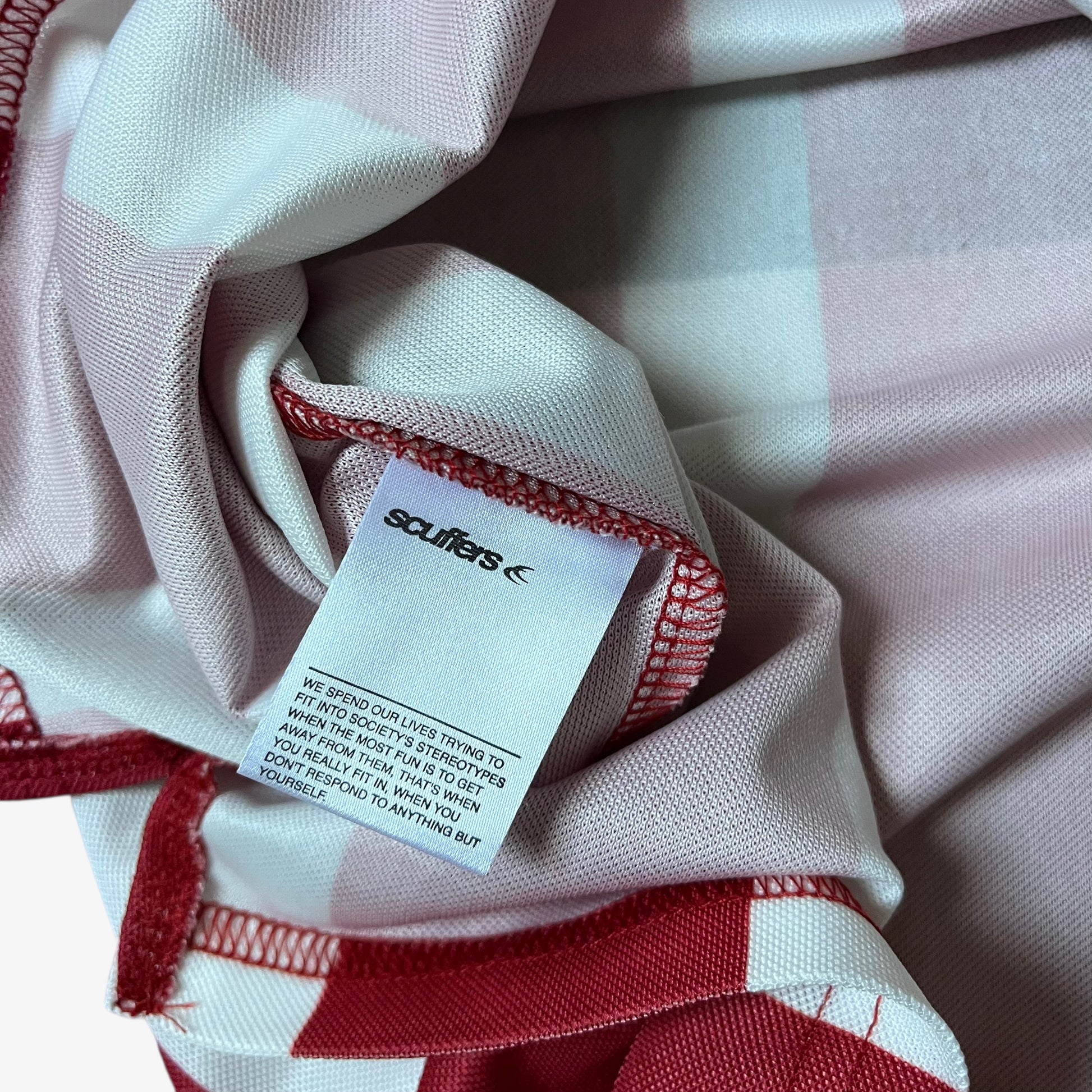 Internal Scuffers label stitched inside of men's red and white striped football jersey.