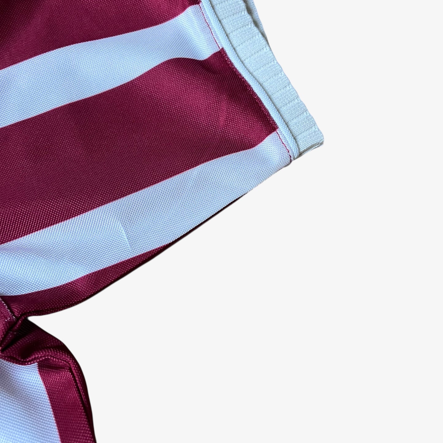 Cuff of men's Scuffers red and white striped football jersey.
