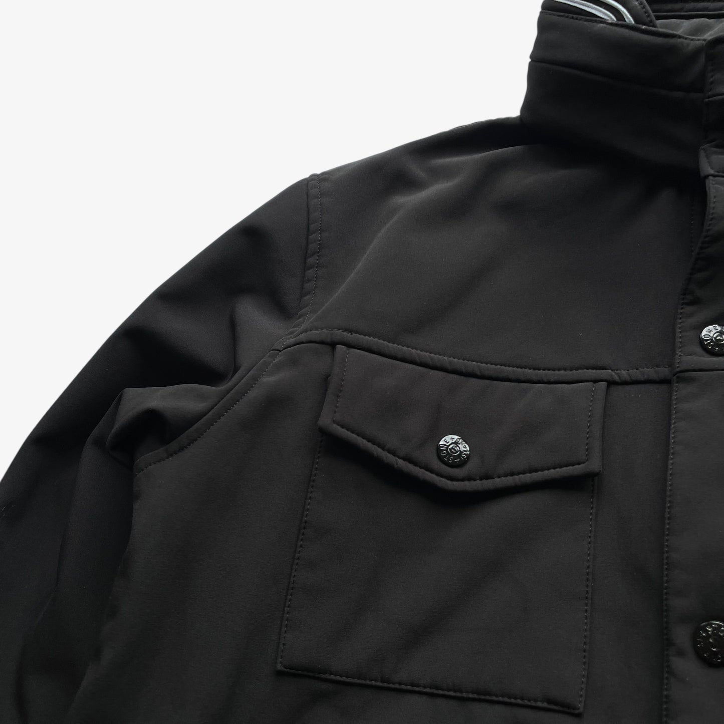 Patina on men's Stone Island Soft Shell R black utility jacket with foldable hood.
