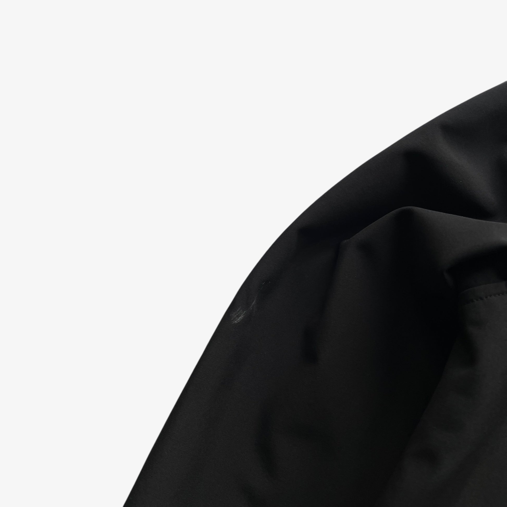 Scuff on men's Stone Island Soft Shell R black utility jacket with foldable hood.