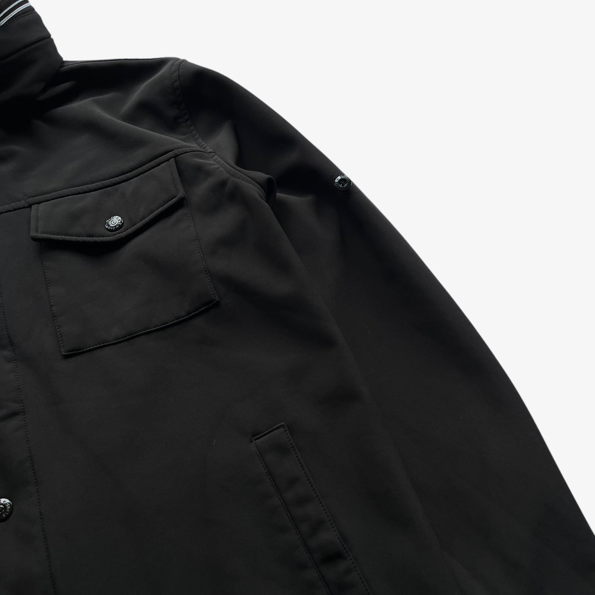Wear on men's Stone Island Soft Shell R black utility jacket with foldable hood.