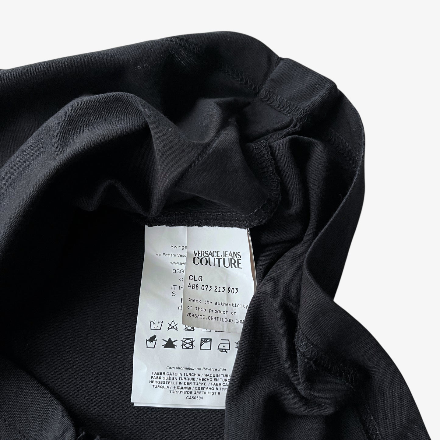 Versace Jeans Couture inside label of men's rhinestone baroque sun face print black t-shirt.