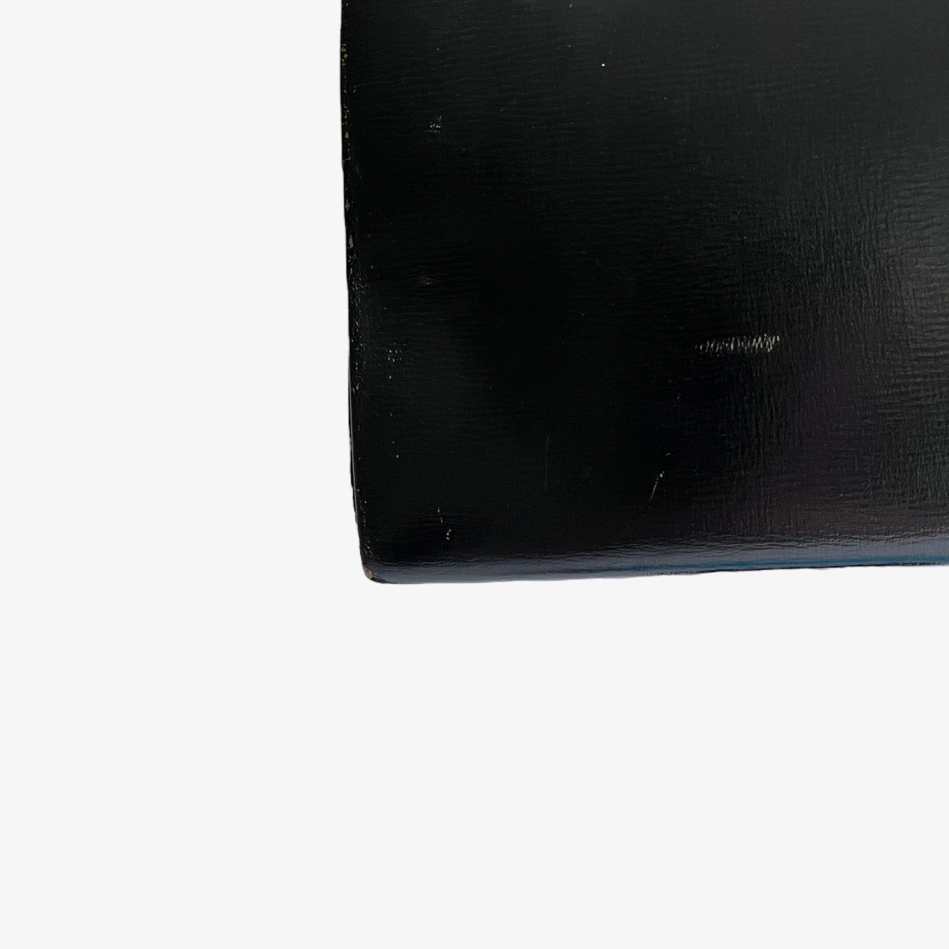 Patina on the corner of a vintage 1950s black leather frame bag.
