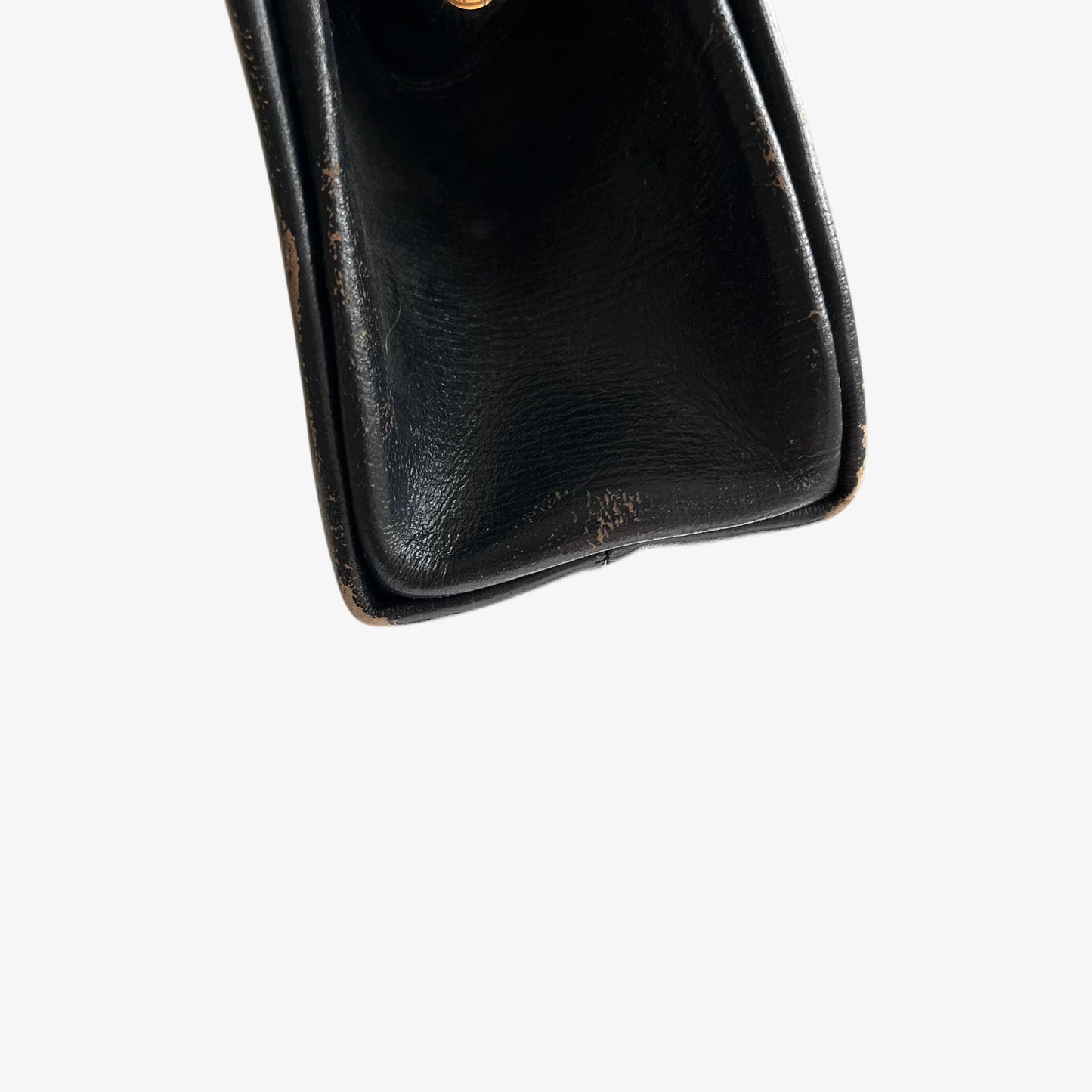 Close up of patina on a vintage 1950s black leather frame bag.
