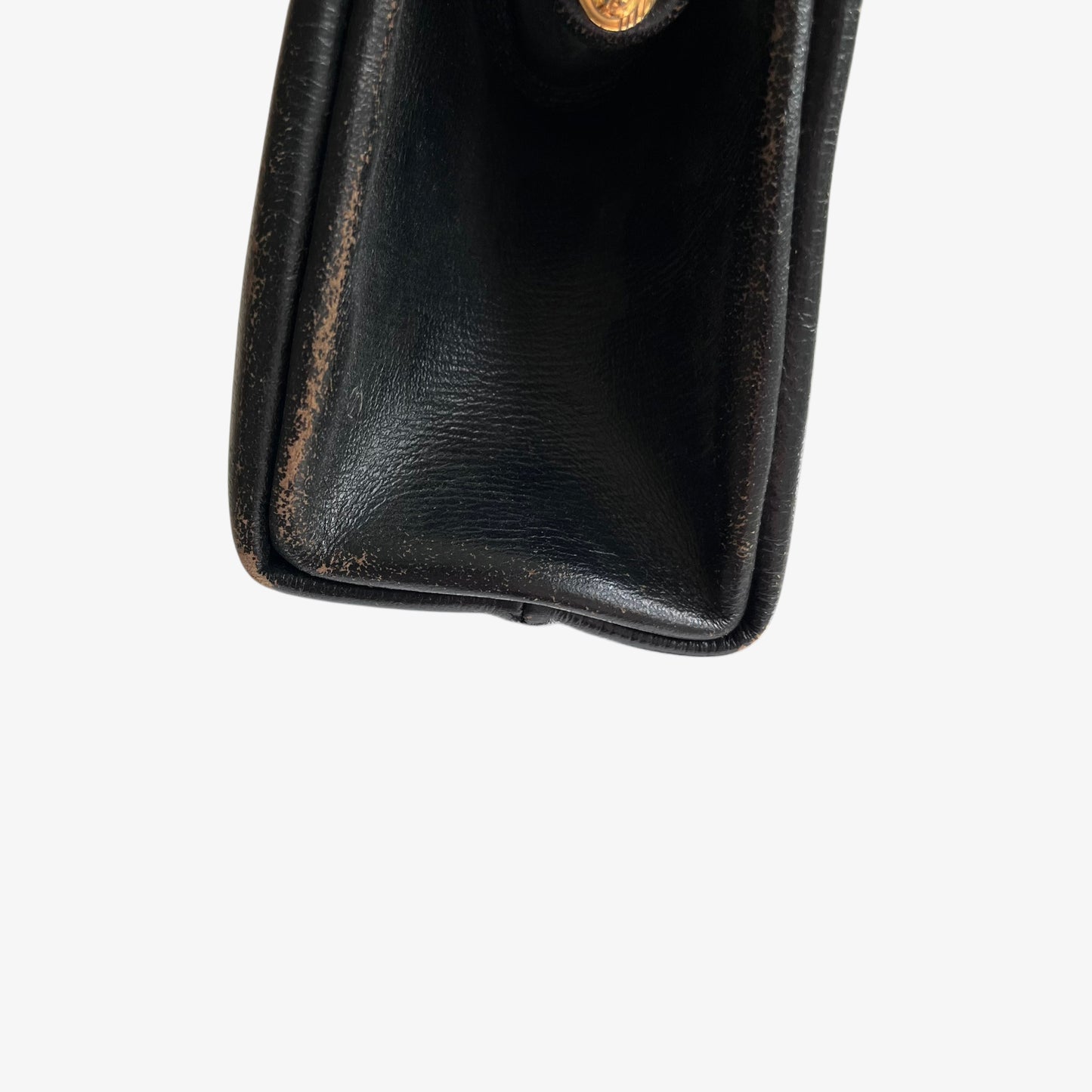 Patina on the corner of a vintage 1950s black leather frame bag.