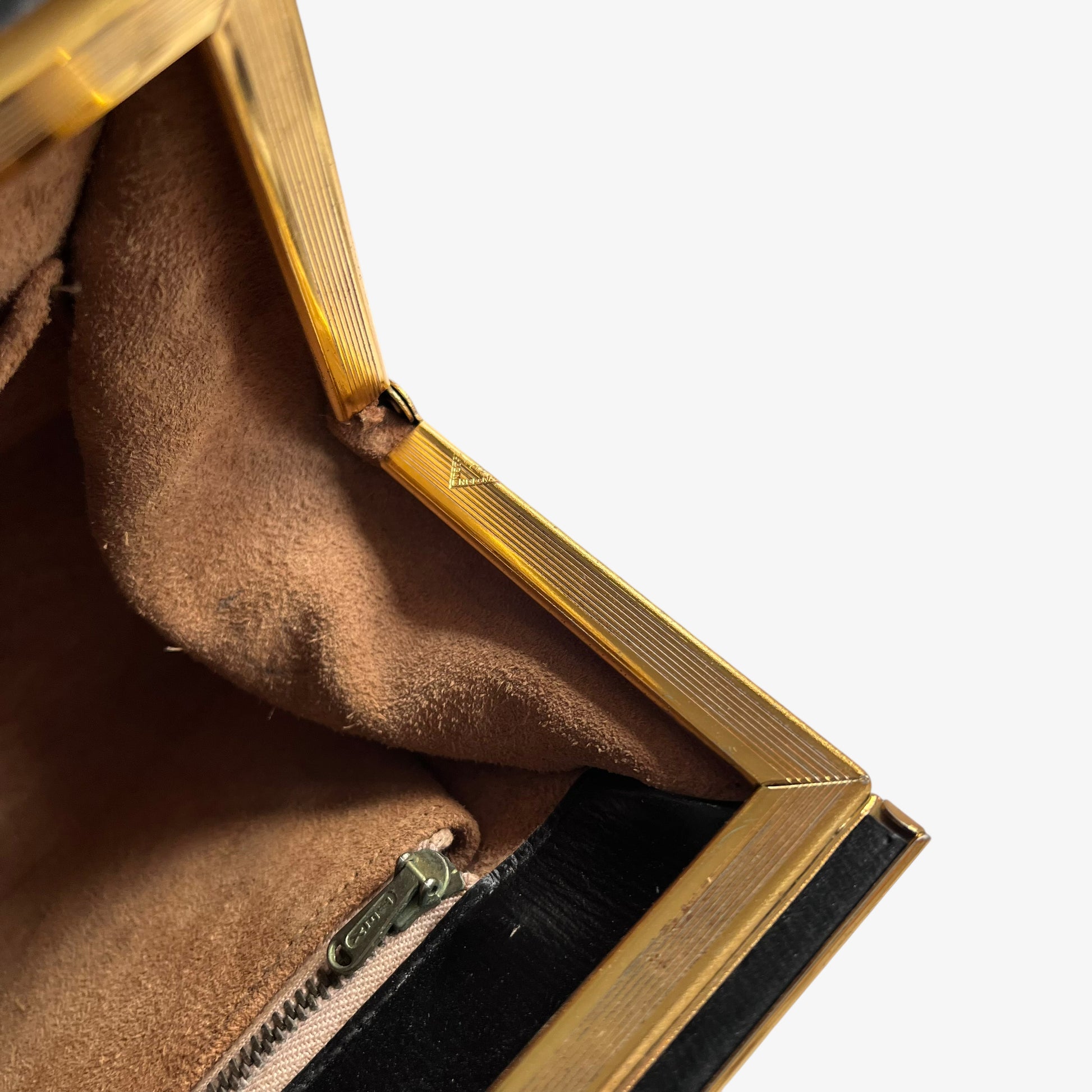 Made in England engraved label inside of a vintage 1950s black leather frame bag.