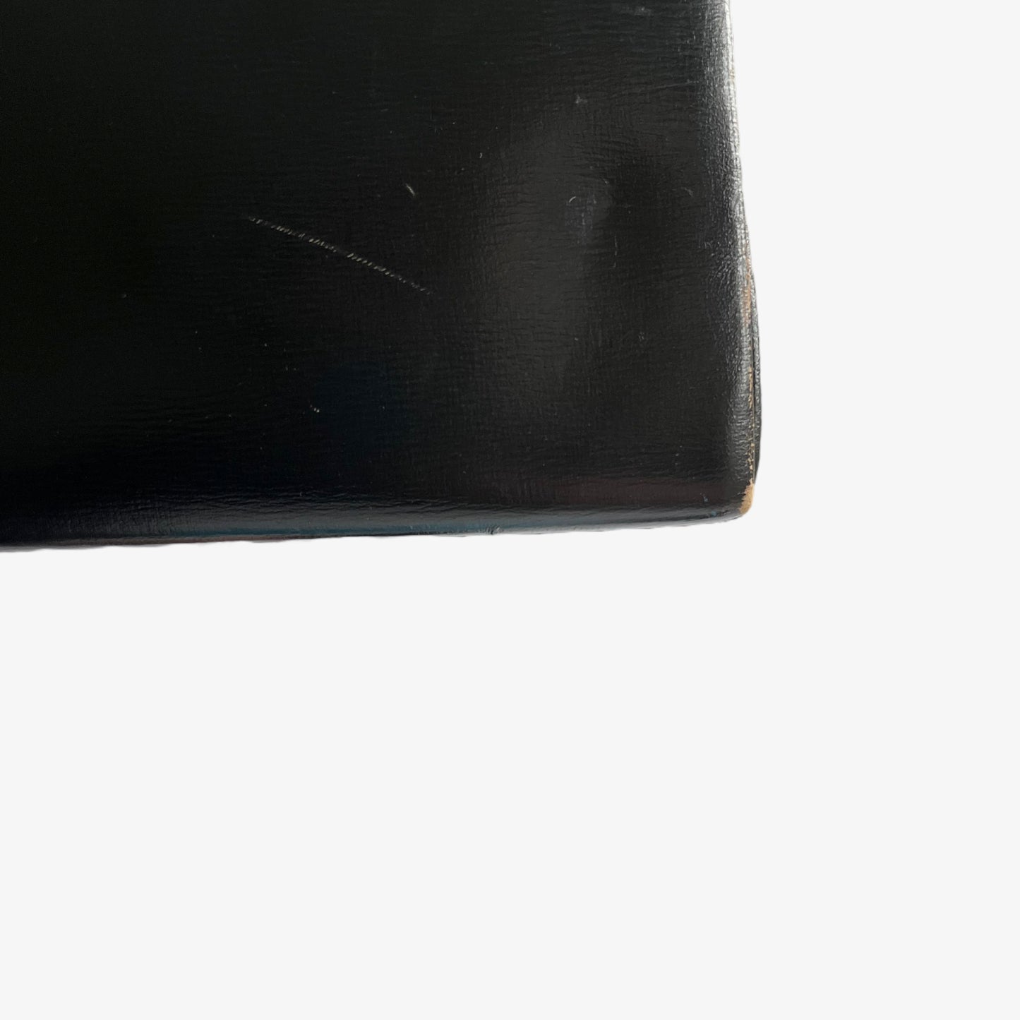 Close up of the scuff on the back of a vintage 1950s black leather frame bag.