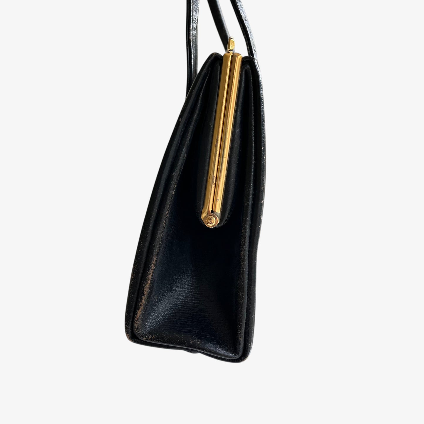 Side view of a vintage 1950s black leather frame bag with a gold clasp.
