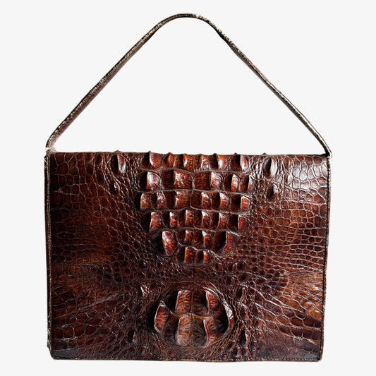 Vintage 1950s brown crocodile leather shoulder bag on a white background.