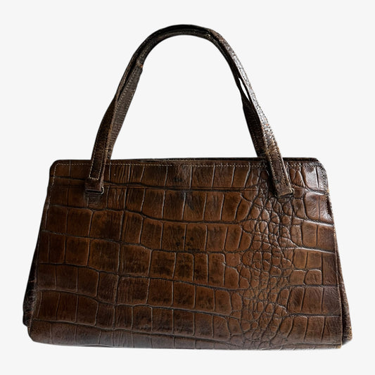 Vintage 1950s crocodile embossed dark brown leather shoulder bag on a white background.