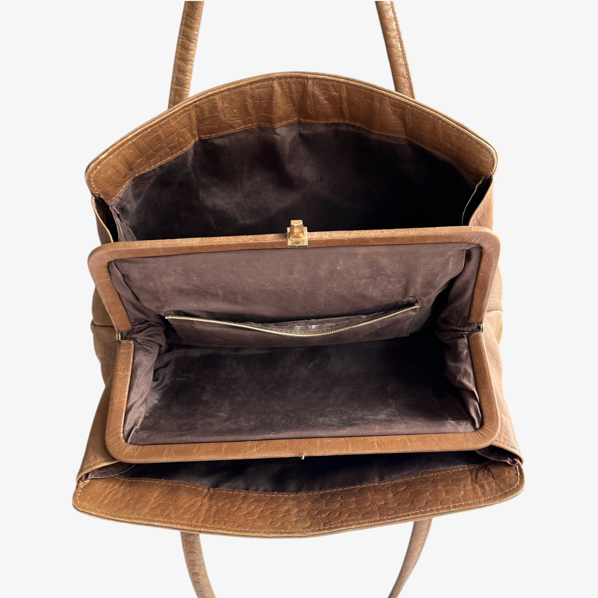 Internal pockets of vintage 1950s crocodile embossed light brown leather shoulder bag on a white background.